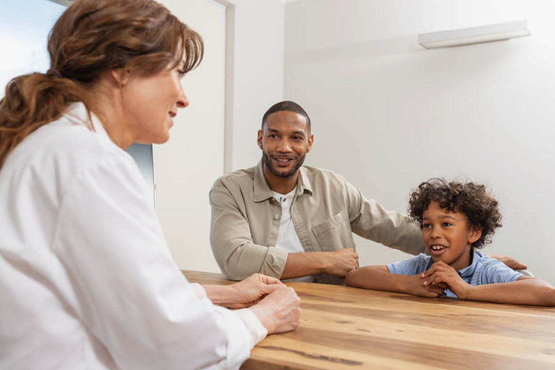 Asthma in children Child sitting with an adult during a medical consultation at a table