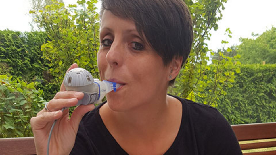 Christine Braune inhaling on her balcony. Christine Braune inhaling on her balcony.