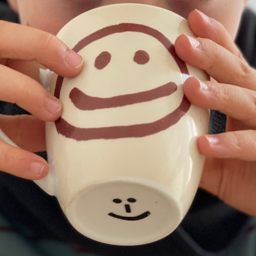 What can be done if a child has mucus in their throat: Drink plenty Close-up of a cup held in the hands of a child