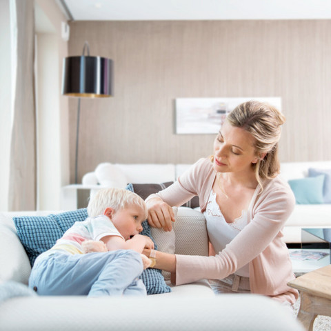 Was kann ich tun, wenn mein Kind ständig hustet? Interview mit Prof. Dr. Carl-Peter Bauer Junge liegt krank auf der Couch, Mutter tröstet ihn