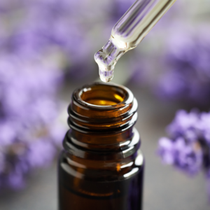 Close-up of brown bottle into which oil is poured using a pipette