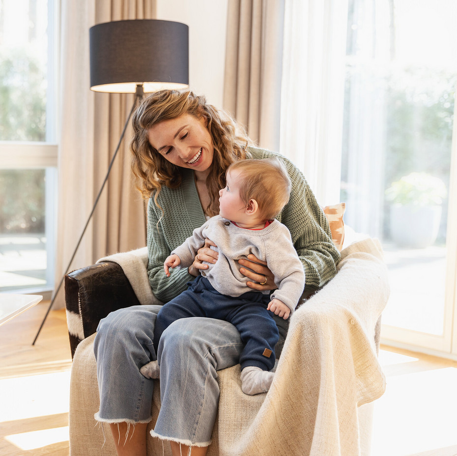 Pregnancy with cystic fibrosis: Mother with child Young woman sitting on a chair with her baby