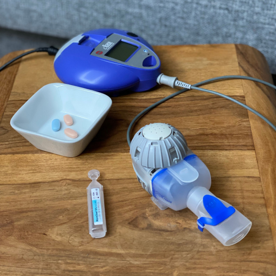 Can you really drop your inhalation therapy altogether if you are on triple CFTR modulators? A cystic fibrosis patient shares her experience Inhalationsgerät mit Controller, Inhalationslösung und Schale mit Tabletten auf einem Tischchen