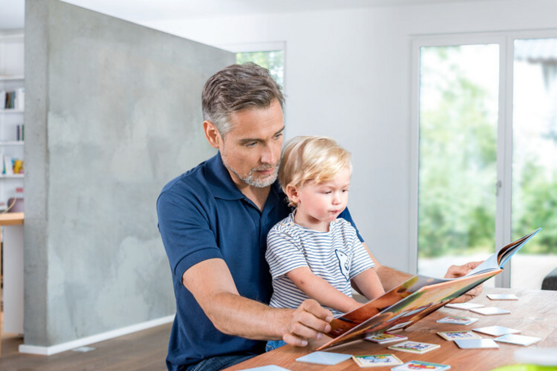 What can be done if a child has mucus in their throat: Words starting with an M Father sitting with son at the table with a book open in front of him