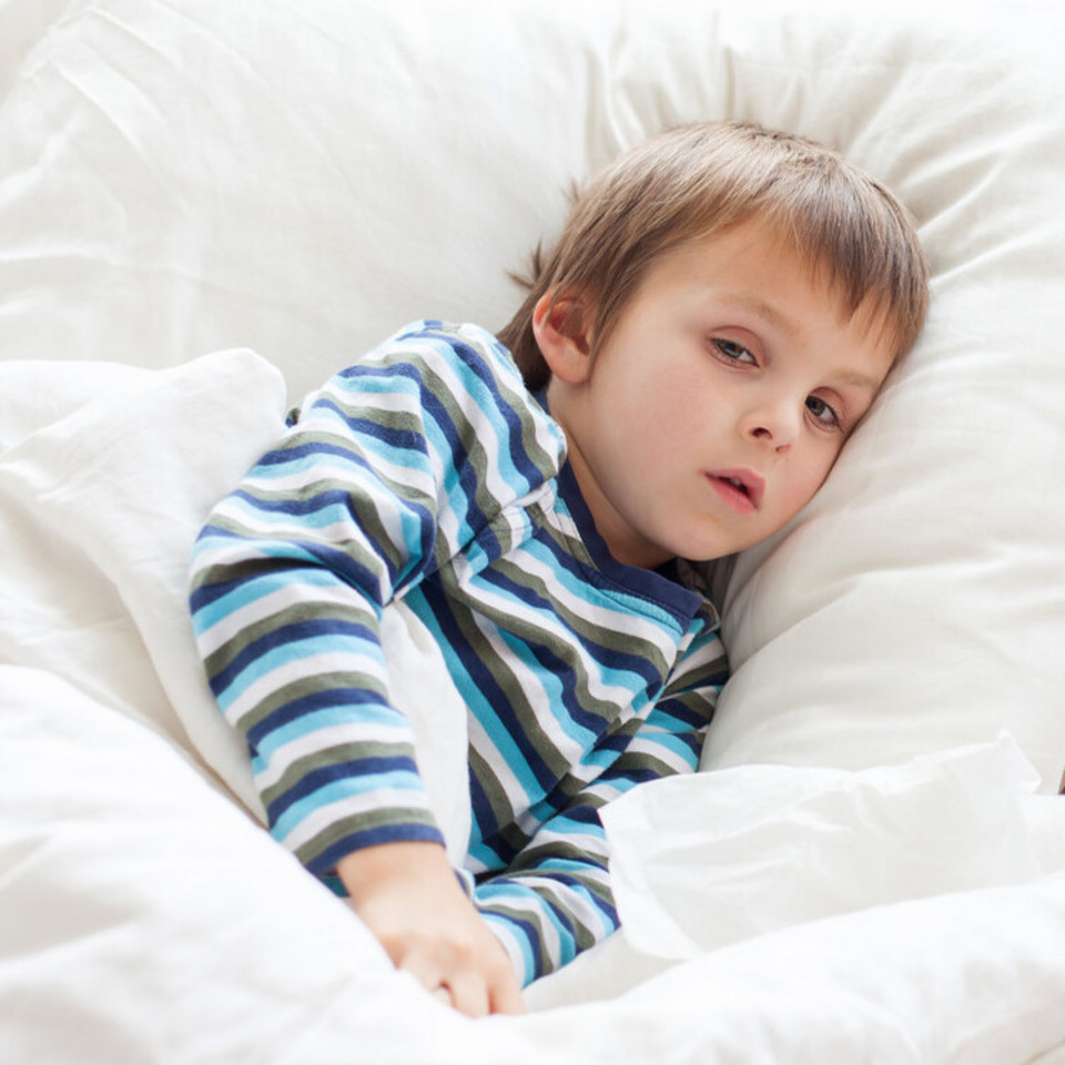 Coughing in children: What can help if your child has a lung infection? Kleines Kind liegt krank im Bett