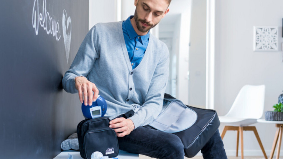 Personalised cystic fibrosis therapy in the age of CFTR modulators – an interview with researcher and patient Dr Zißler Young man sits on bench in aisle and puts inhalation device in bag