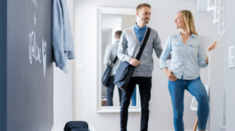 Zeit sparen bei der Atemtherapie: 3 Tipps für Lungenpatienten Mann verabschiedet sich im Gang von Frau, im Vordergrund liegt ein Inhalationssystem