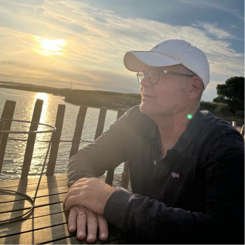 Relapsing polychondritis – interview with a patient Mann sitzt an einem Tisch am Seeufer und schaut hinaus auf den See