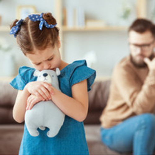 Kind schmollt und hat einen Teddybär in den Armen 