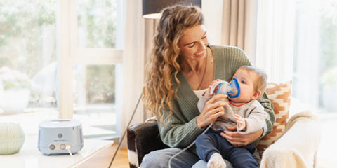 Mutter behandelt ihr Kind, welches an einer Bronchiolitis leidet