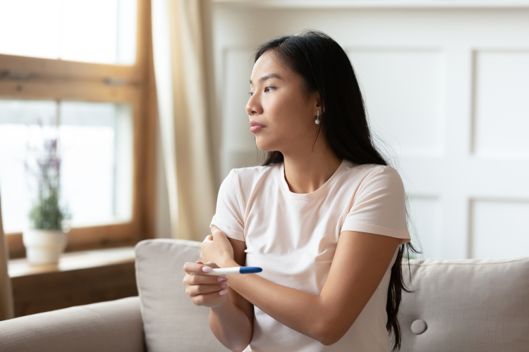 Pregnancy with cystic fibrosis: testing Young woman holding pregnancy test in hand