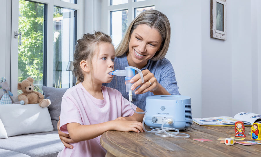 Wet inhalation with nebulizer Mother helps her child during the inhalation therapy with a nebuliser.